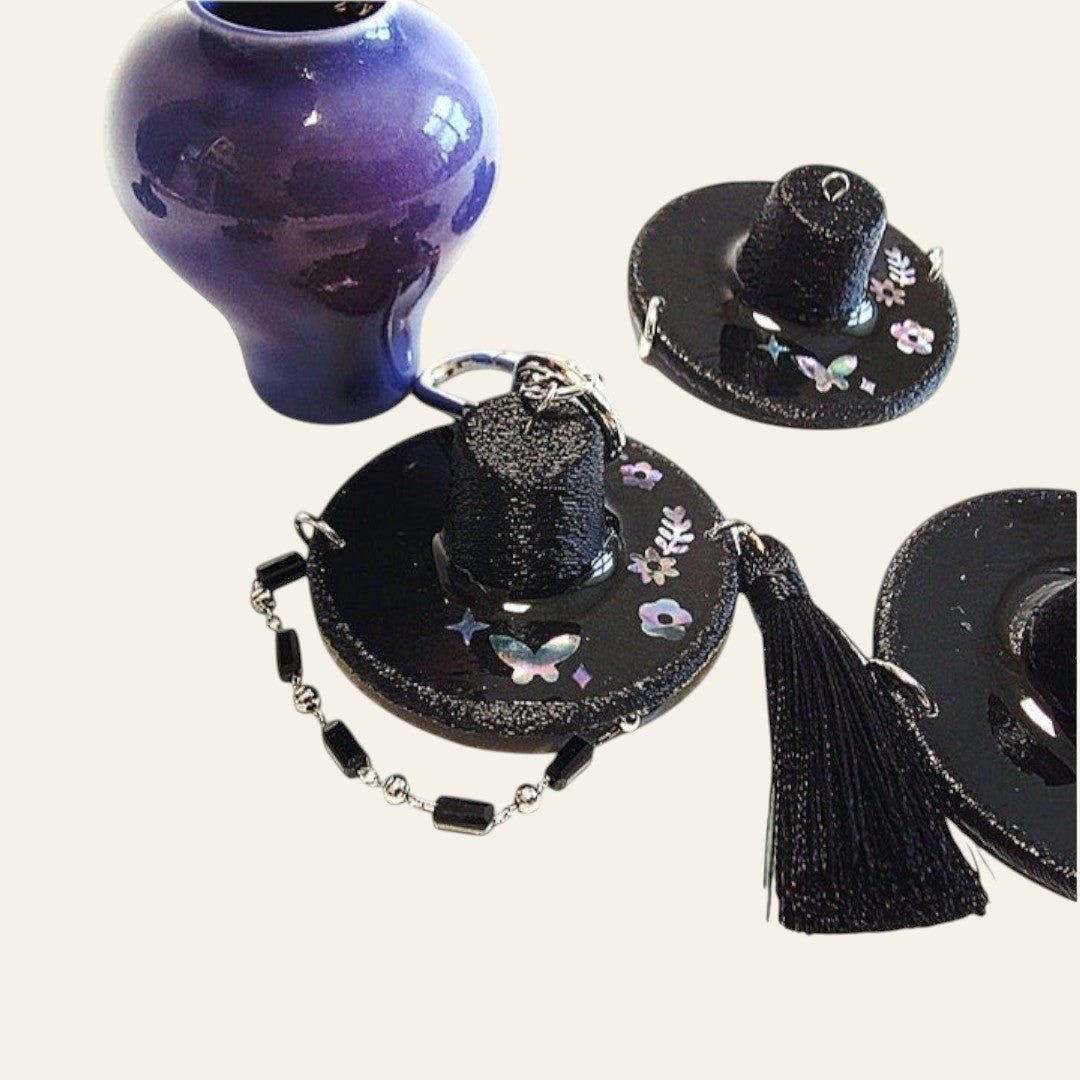 HanPorta mother-of-pearl gat hat keyring featuring butterfly and floral inlays with a black tassel and beaded strap.